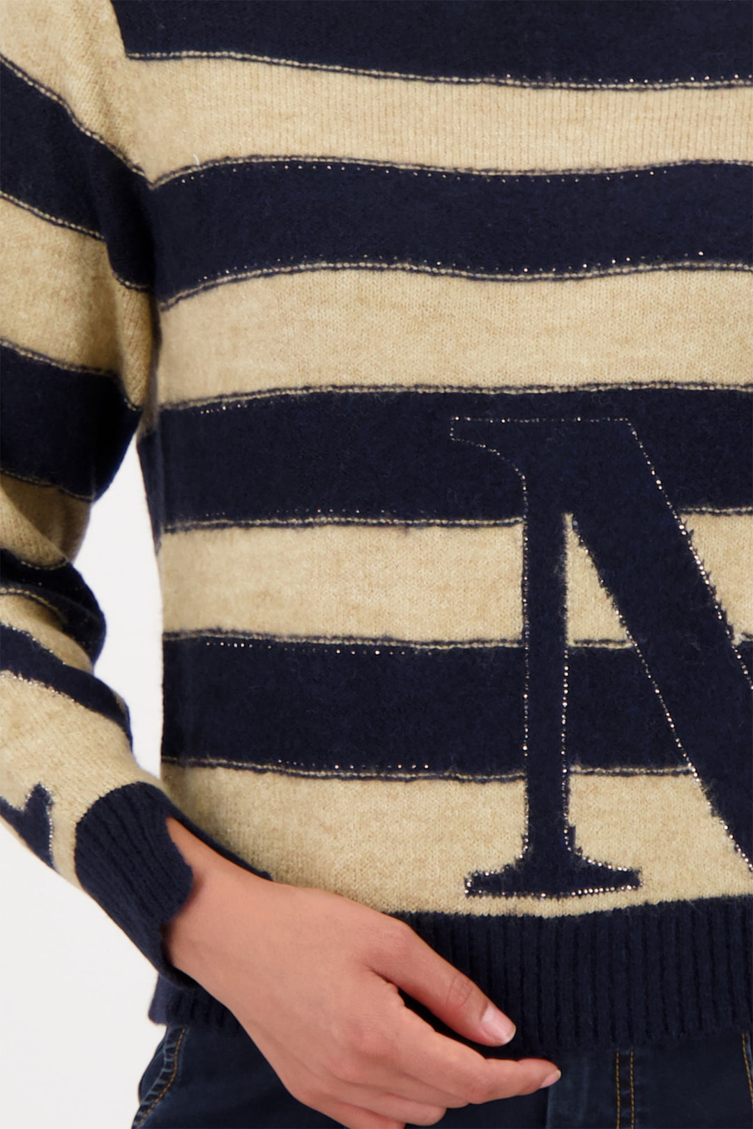 Close-up of a navy and beige striped sweater with a large letter 'A'.