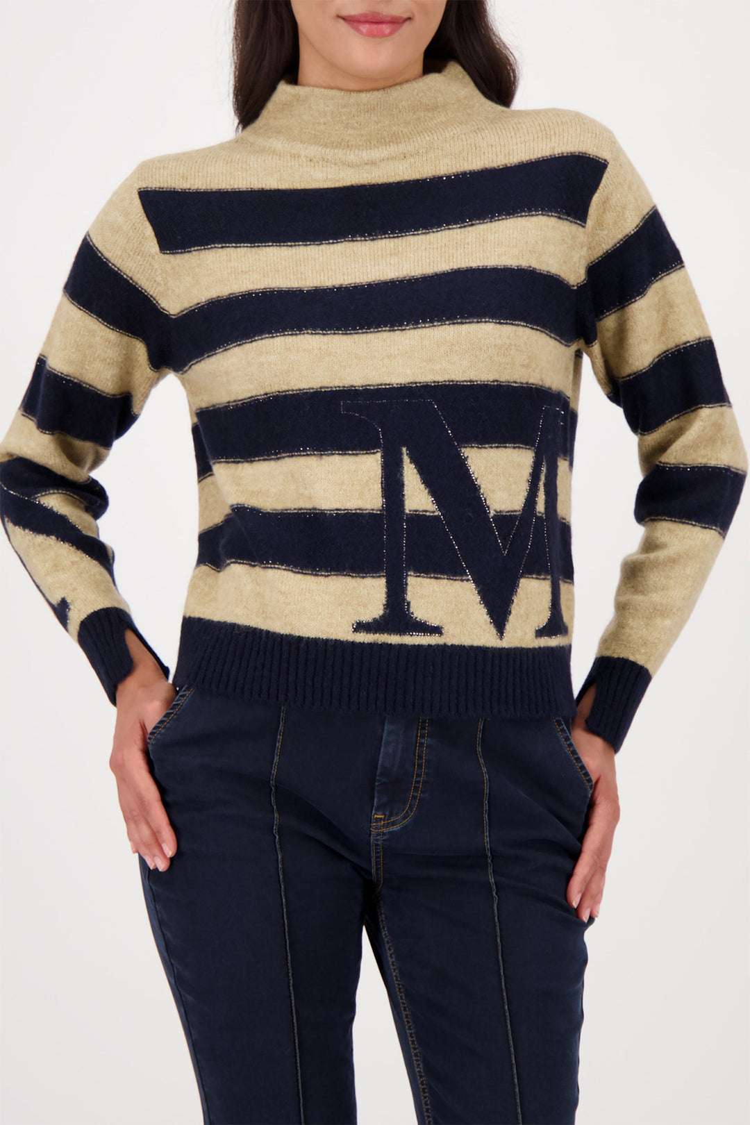 Beige and navy striped sweater with a logo worn by a person on a white background