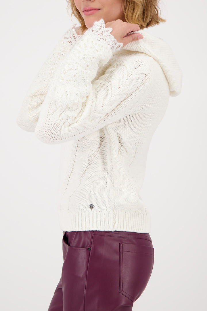 White knitted sweater with a textured pattern worn by a person on a white background