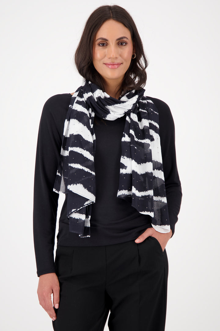 Woman wearing a black and white patterned scarf against a white background
