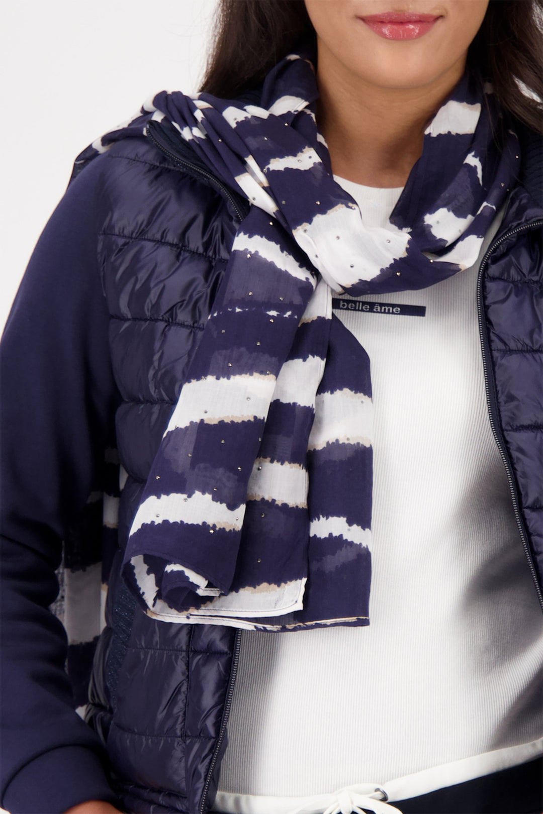 Person wearing a navy and white striped scarf with a puffer jacket.