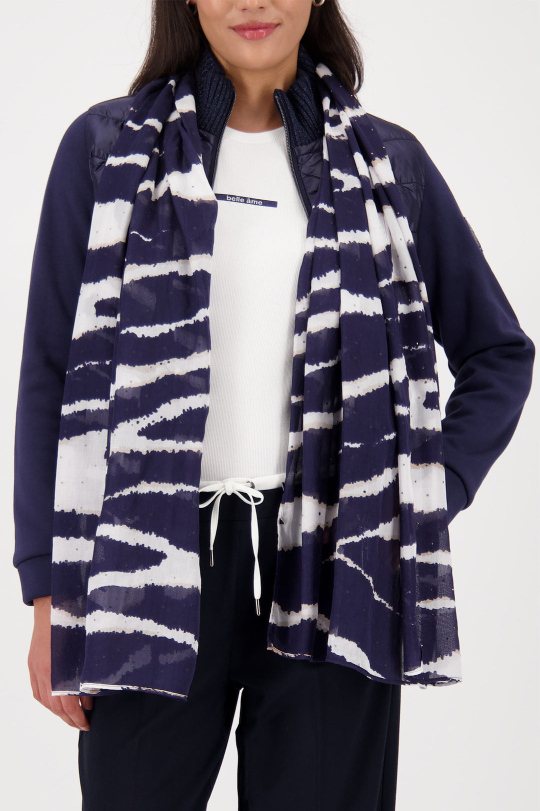 Person wearing a navy and white striped scarf with a plain background