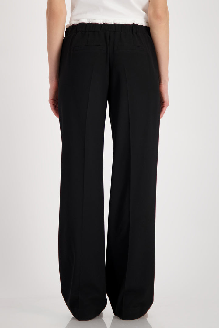 Black wide-leg pants worn by a person on a white background