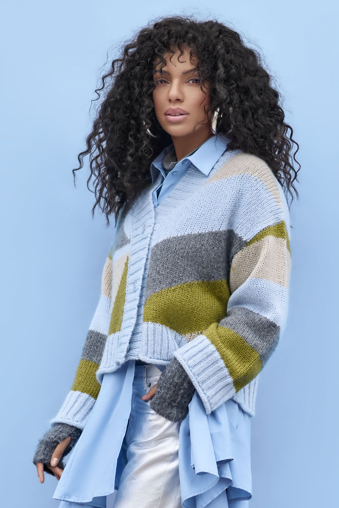 Woman wearing a colorful striped sweater against a light blue background