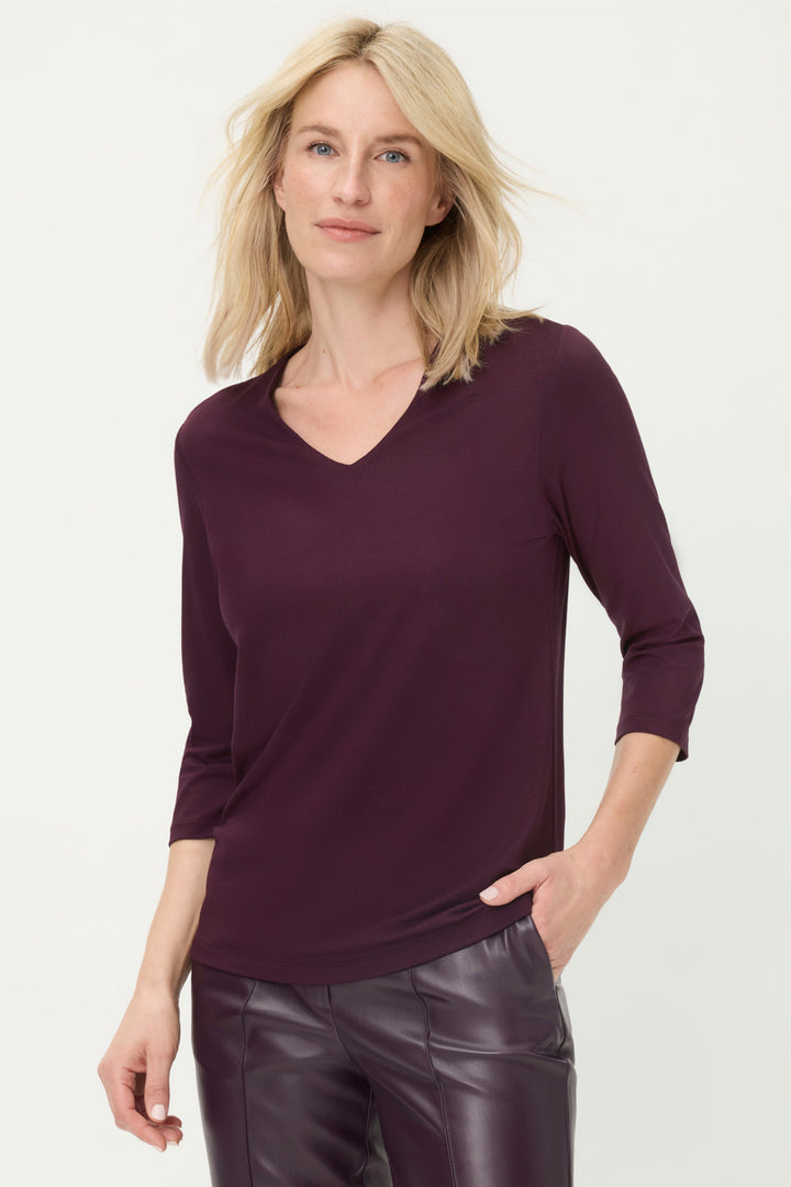 Woman wearing a purple sweater and leather pants on a white background