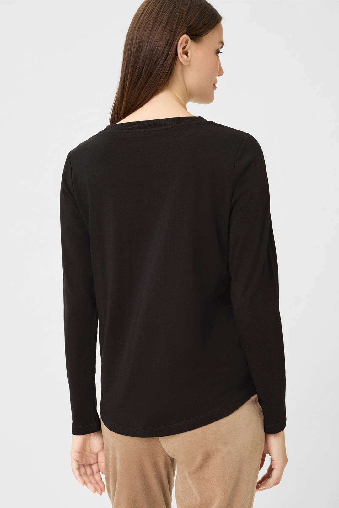 Person wearing a black long-sleeve top on a white background