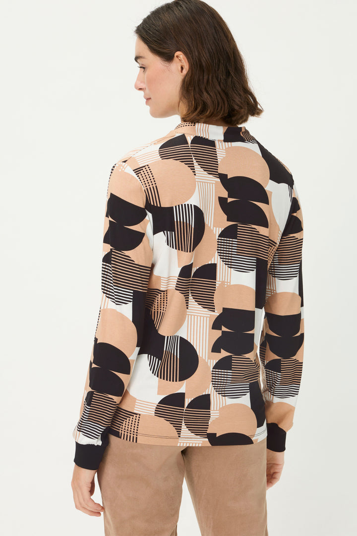 Woman wearing a patterned long-sleeve top on a white background