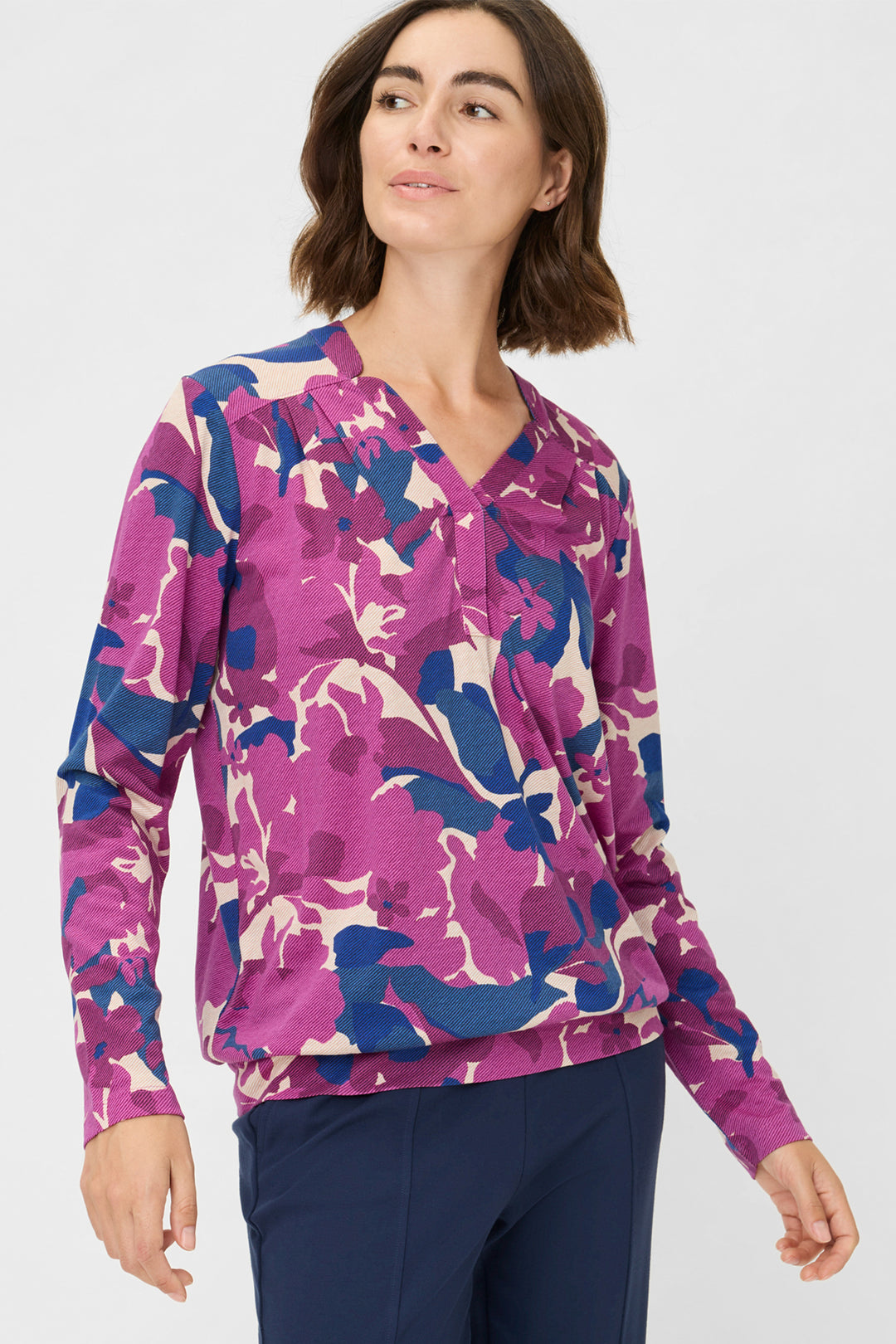 Woman wearing a purple and blue patterned shirt against a white background