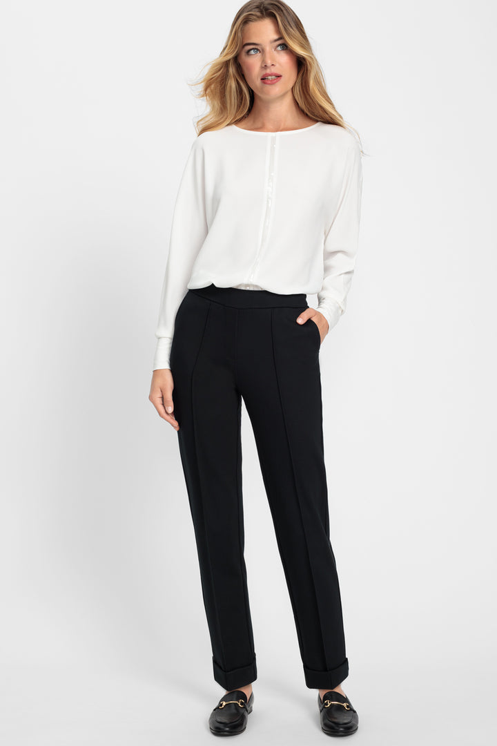 Woman wearing a white blouse and black pants on a white background