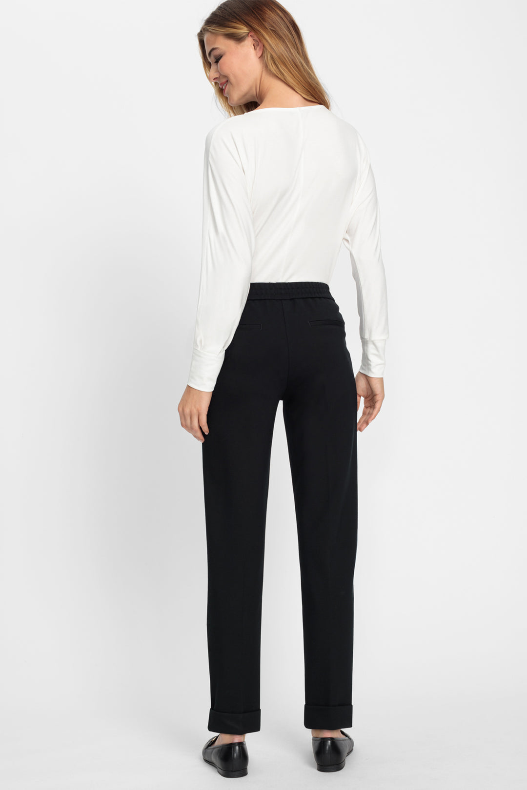 Woman wearing a white blouse and black pants on a white background
