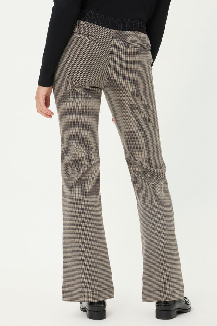 Brown flared pants worn by a person on a white background