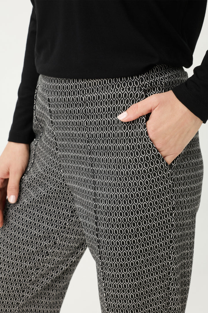 Person wearing gray patterned pants with a plain background