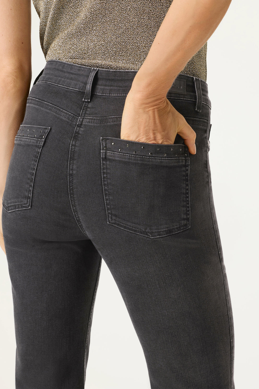 Person wearing black jeans with a neutral background