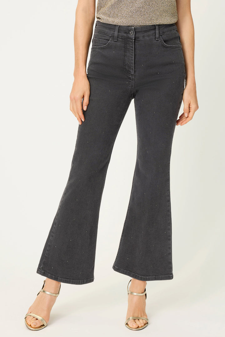 Person wearing black flared jeans on a white background