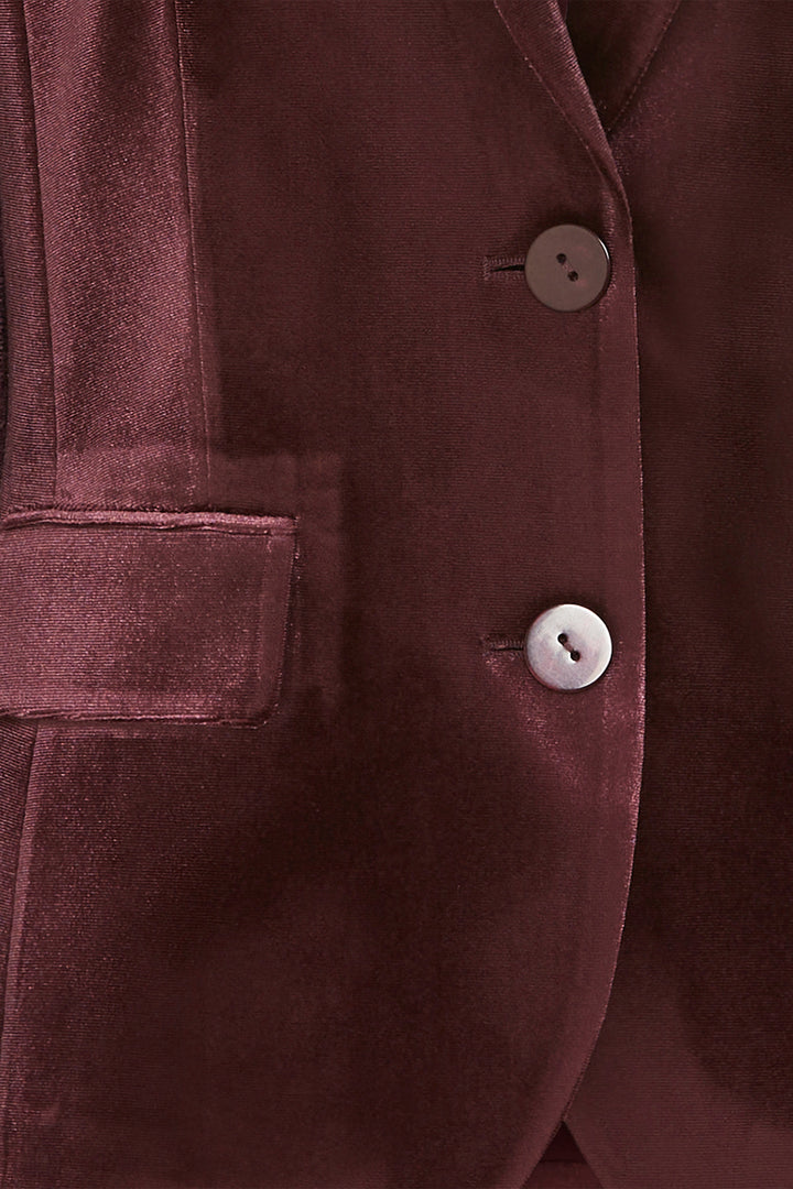 Close-up of a Dark wine velvet jacket with buttons and a pocket.