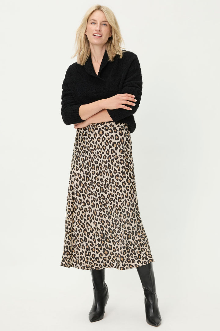 Woman wearing a black sweater and leopard print skirt on a white background