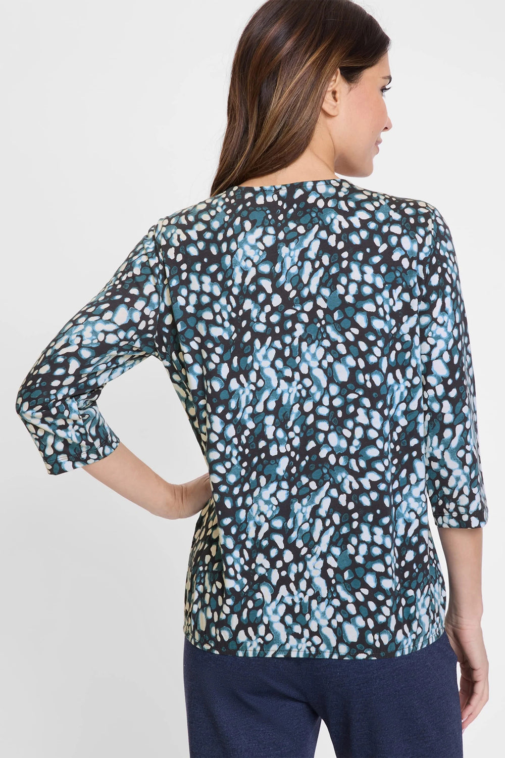 Woman wearing a patterned blouse with a plain background