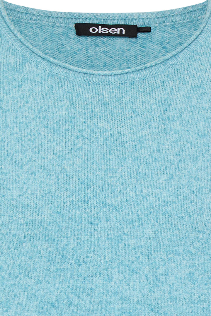 Close-up of a light blue shirt with 'olsen' label on collar