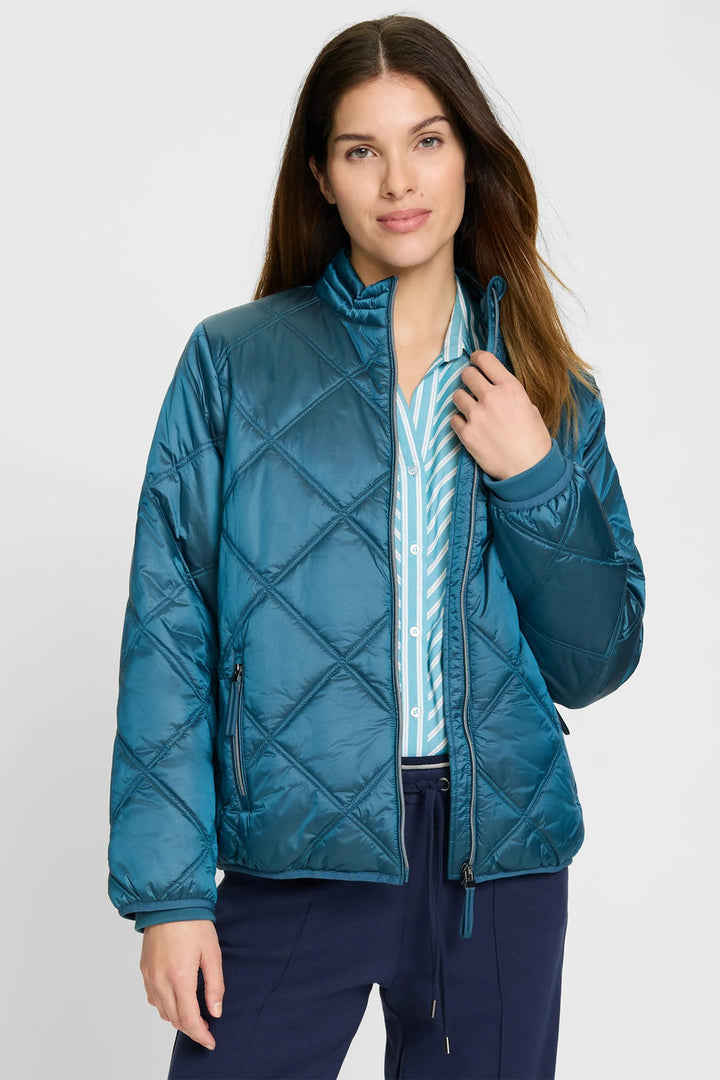 Woman wearing a blue quilted jacket on a white background
