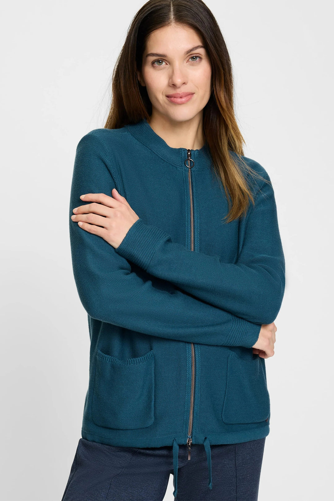 Woman wearing an Olsen teal zip-up hoodie on a white background