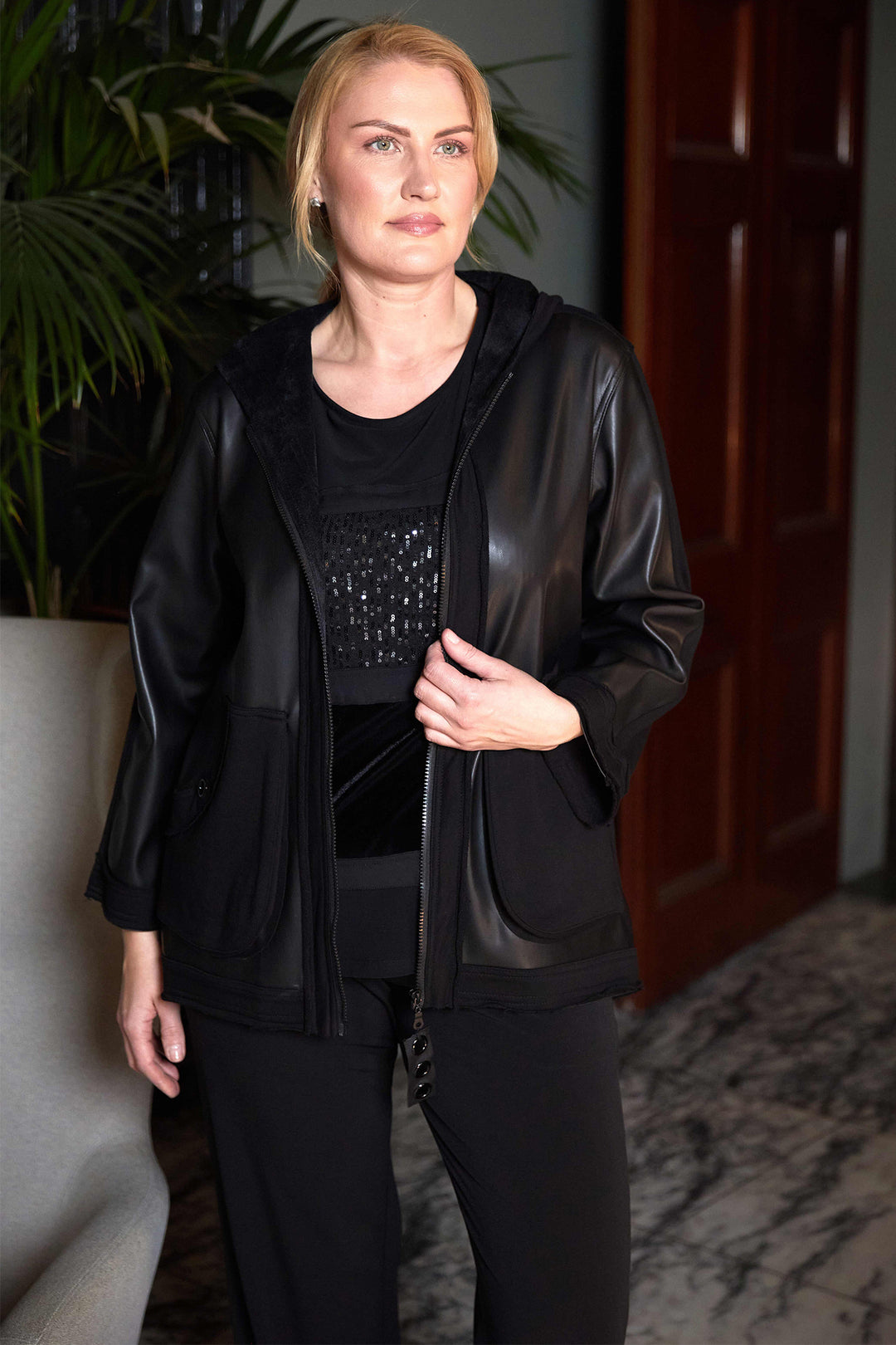 Woman wearing a black leather jacket and outfit indoors