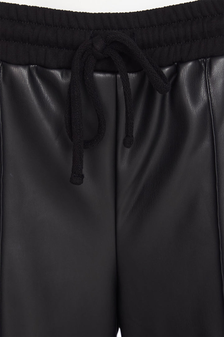 Black leather shorts with drawstring waistband on a plain background
