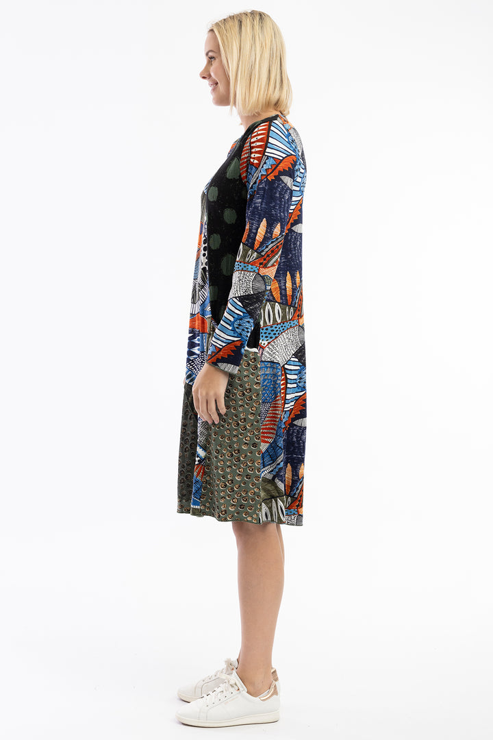 Woman wearing a colorful patterned dress with a white background