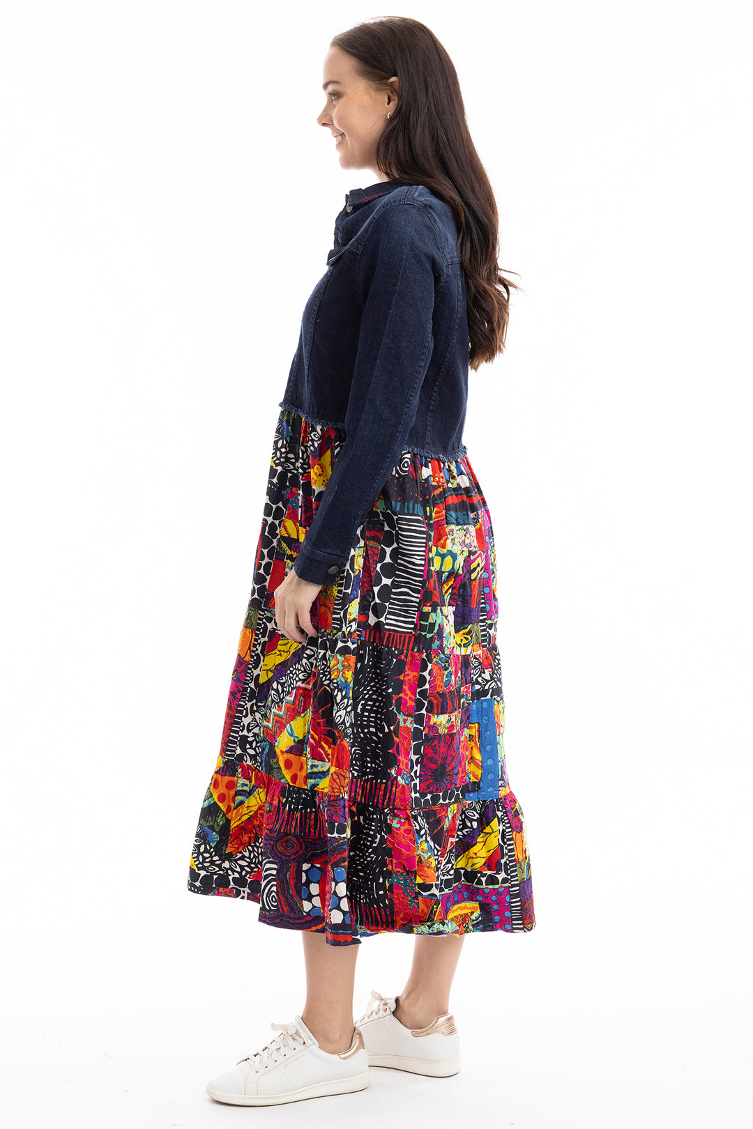 Woman wearing a colorful patterned skirt and navy sweater on a white background