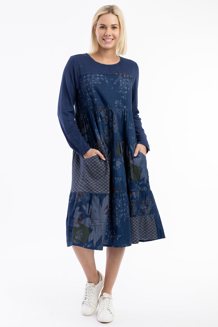 Woman wearing a blue dress with floral patterns on a white background