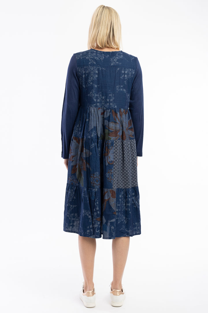 Woman wearing a blue patterned dress on a white background