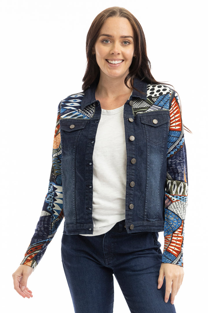Woman wearing a colorful denim jacket with a white background