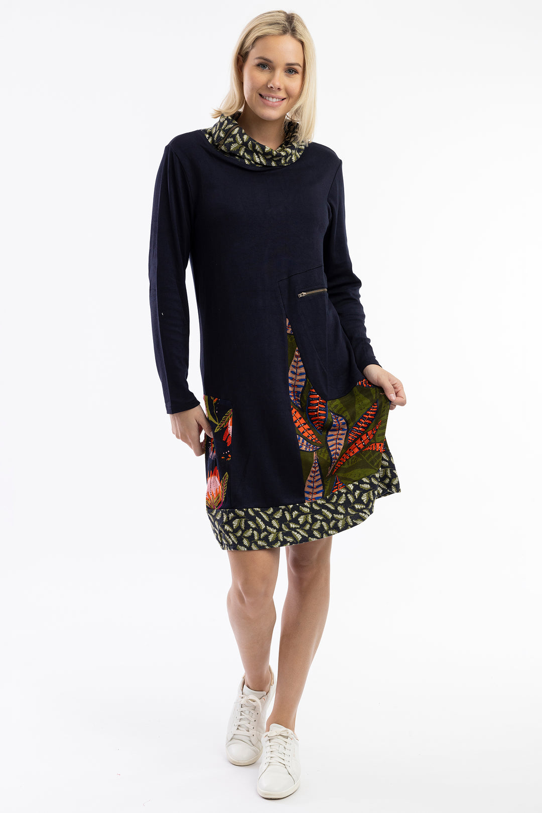 Woman wearing a dark blue dress with colorful patterns on a white background