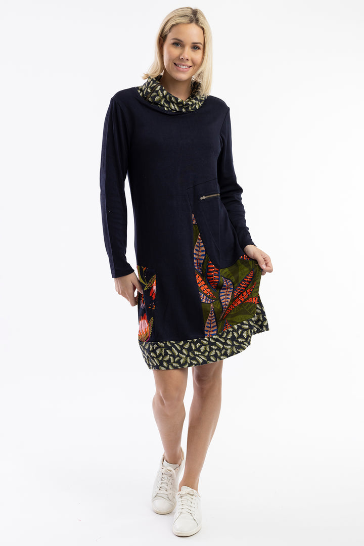 Woman wearing a dark blue dress with colorful patterns on a white background