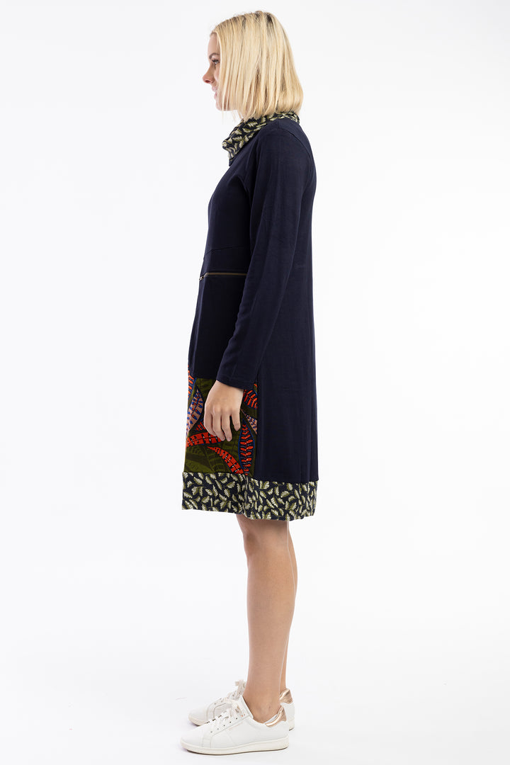 Woman wearing a dark blue dress with patterned sections on a white background