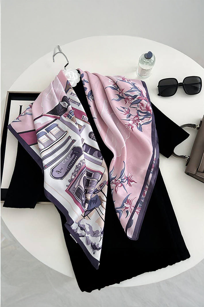Two patterned scarves on a black garment with sunglasses and a bottle on a white surface.