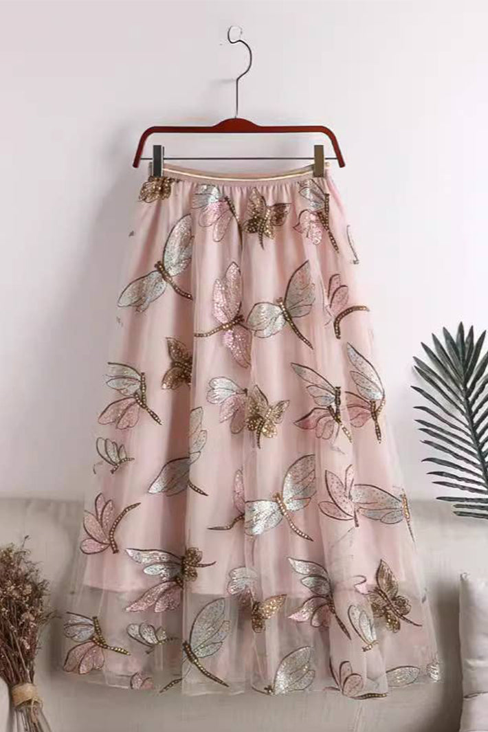 Pink floral embroidered skirt on a hanger against a white background