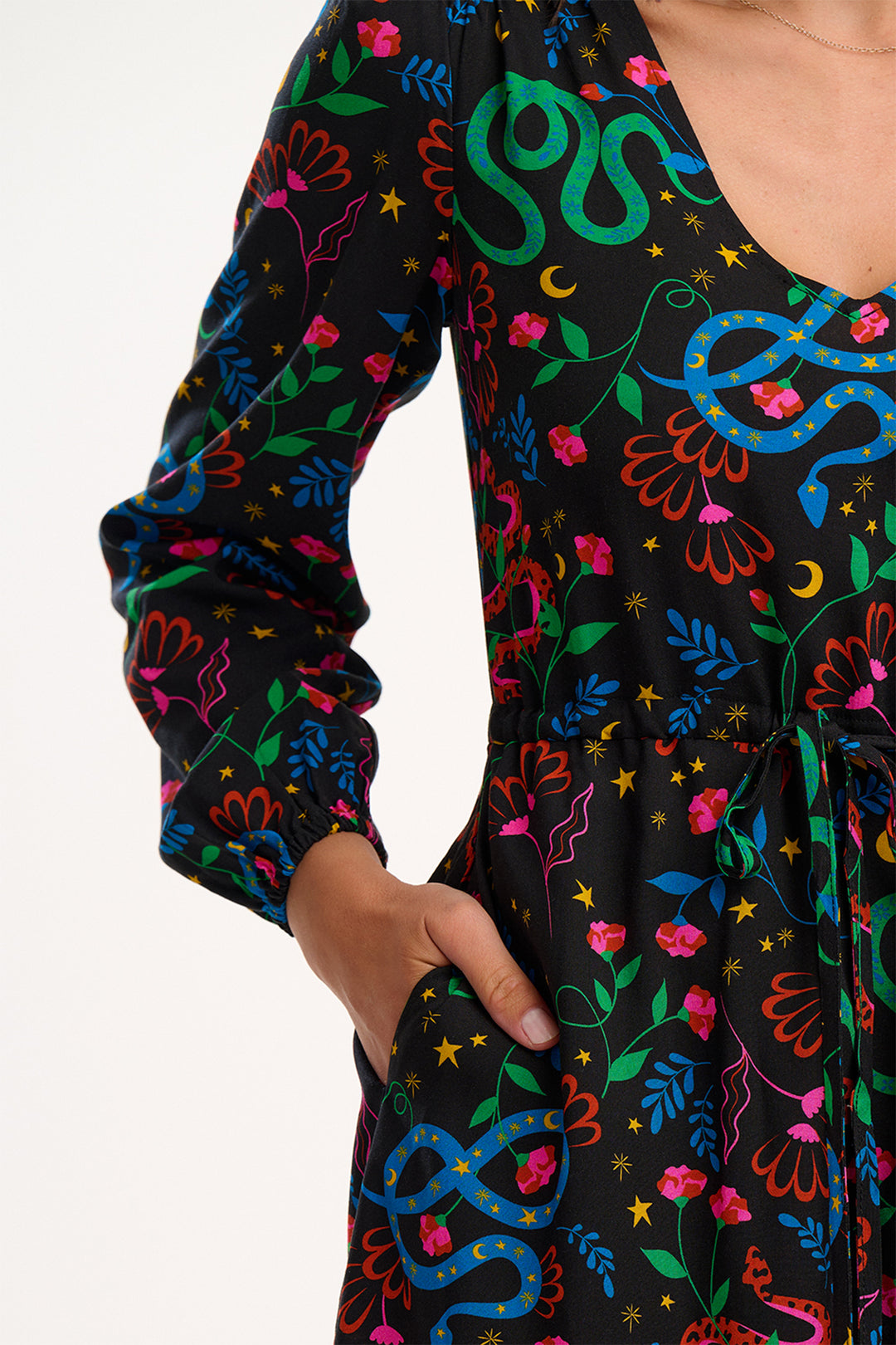 Black dress with colorful snake and floral patterns on a plain background