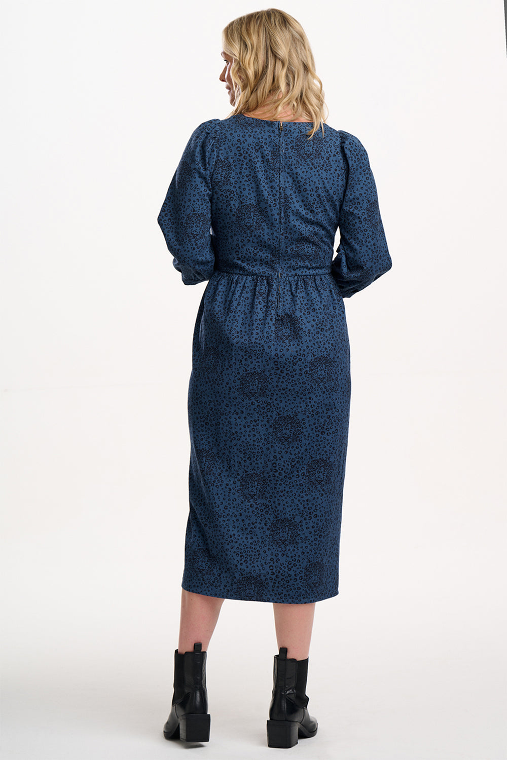 Woman wearing a blue patterned dress on a white background
