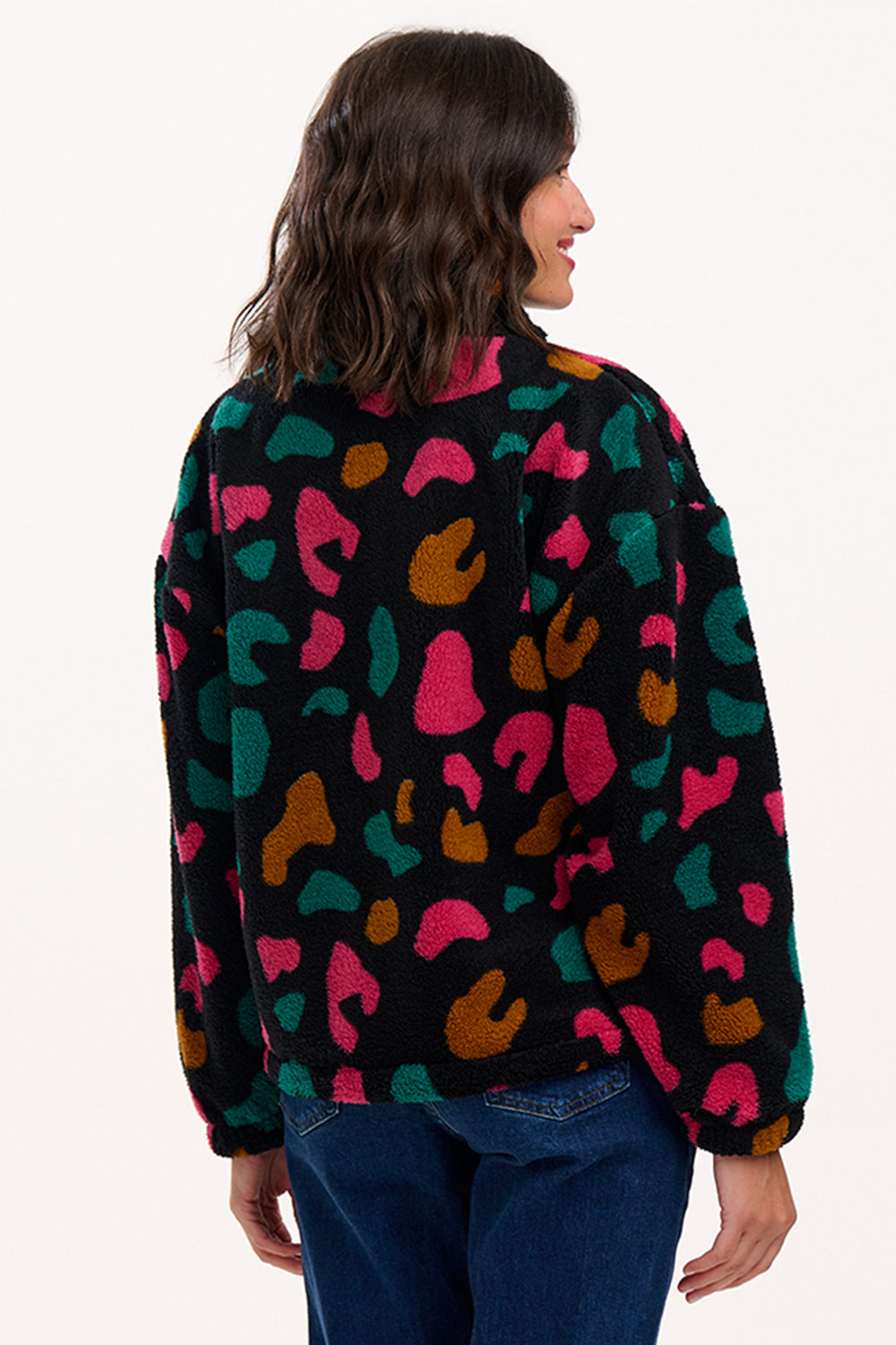 Person wearing a colorful patterned sweater on a white background