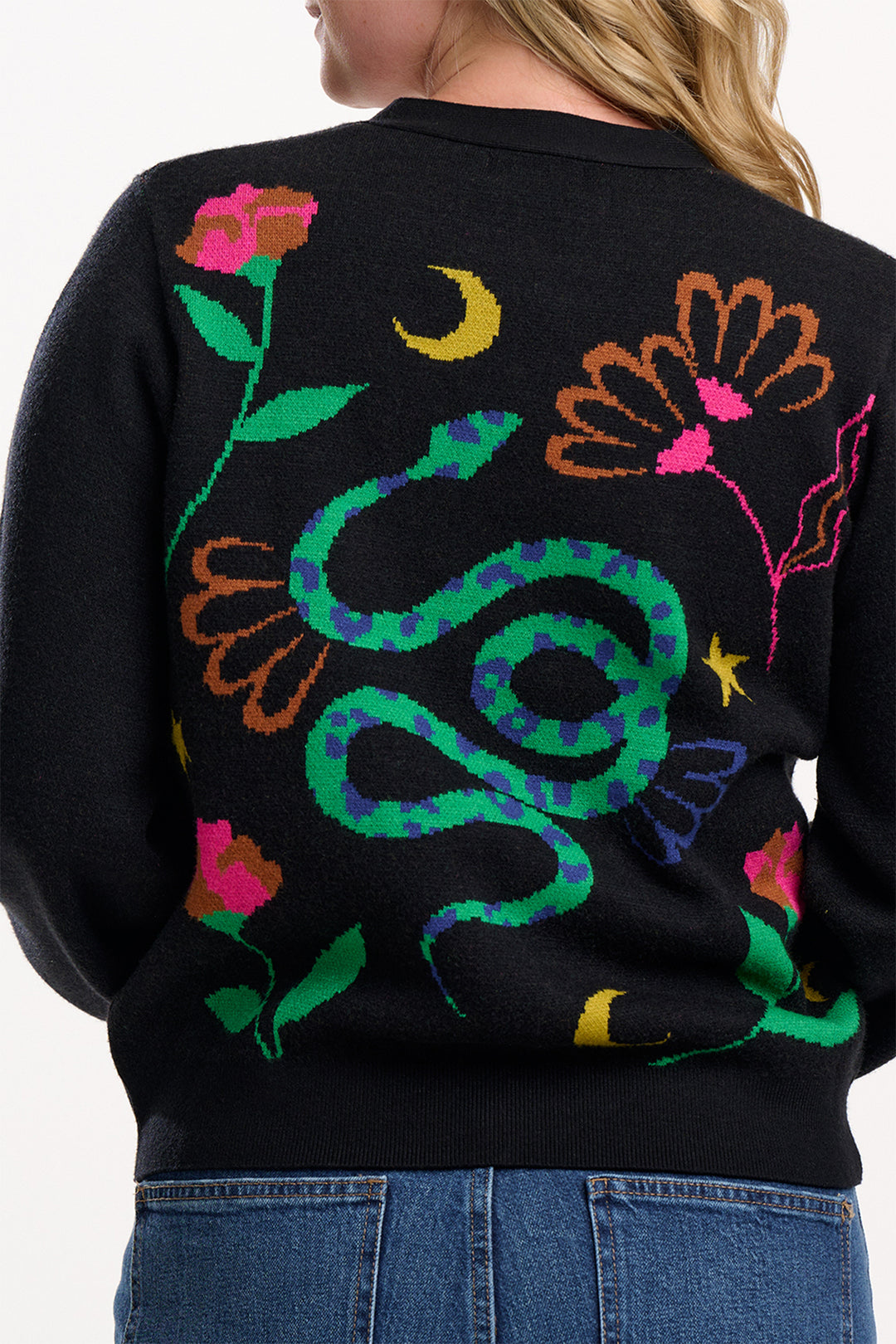 Black sweater with colorful snake and floral design worn by a person