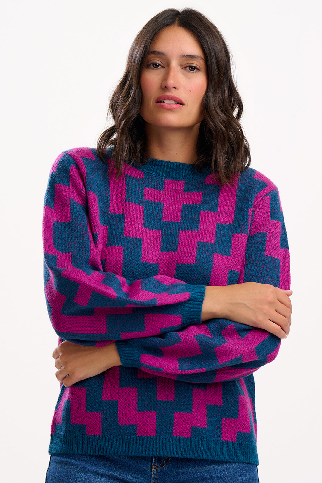 Woman wearing a blue and pink patterned sweater on a white background