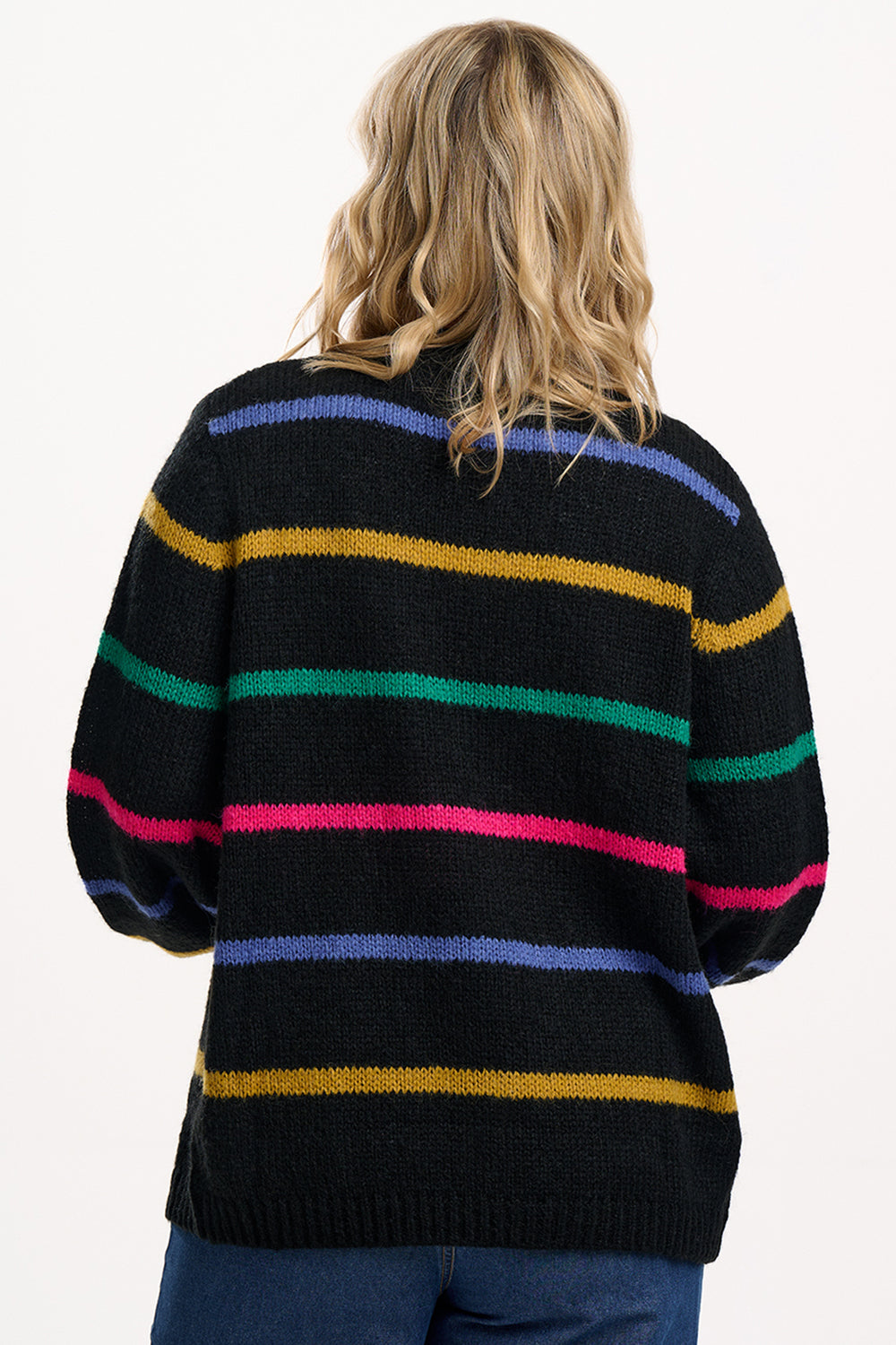 Person wearing a black sweater with colorful horizontal stripes on a white background
