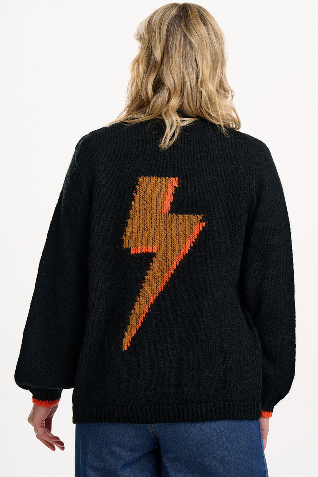 Person wearing a black sweater with a brown lightning bolt design on the back.