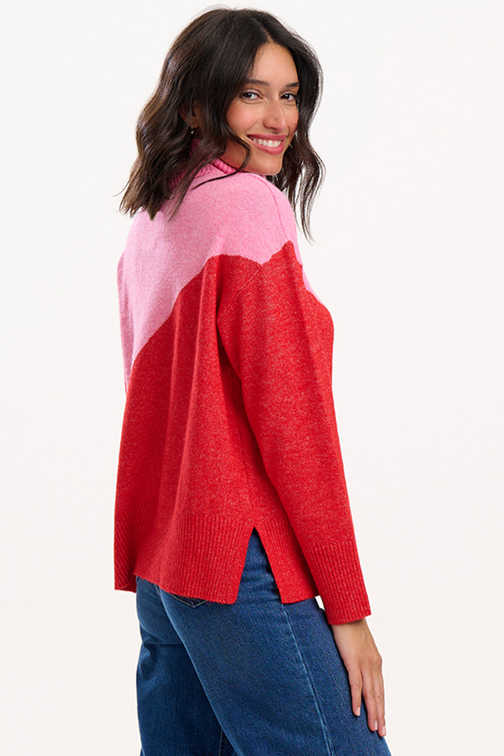 Woman wearing a red and pink sweater on a white background