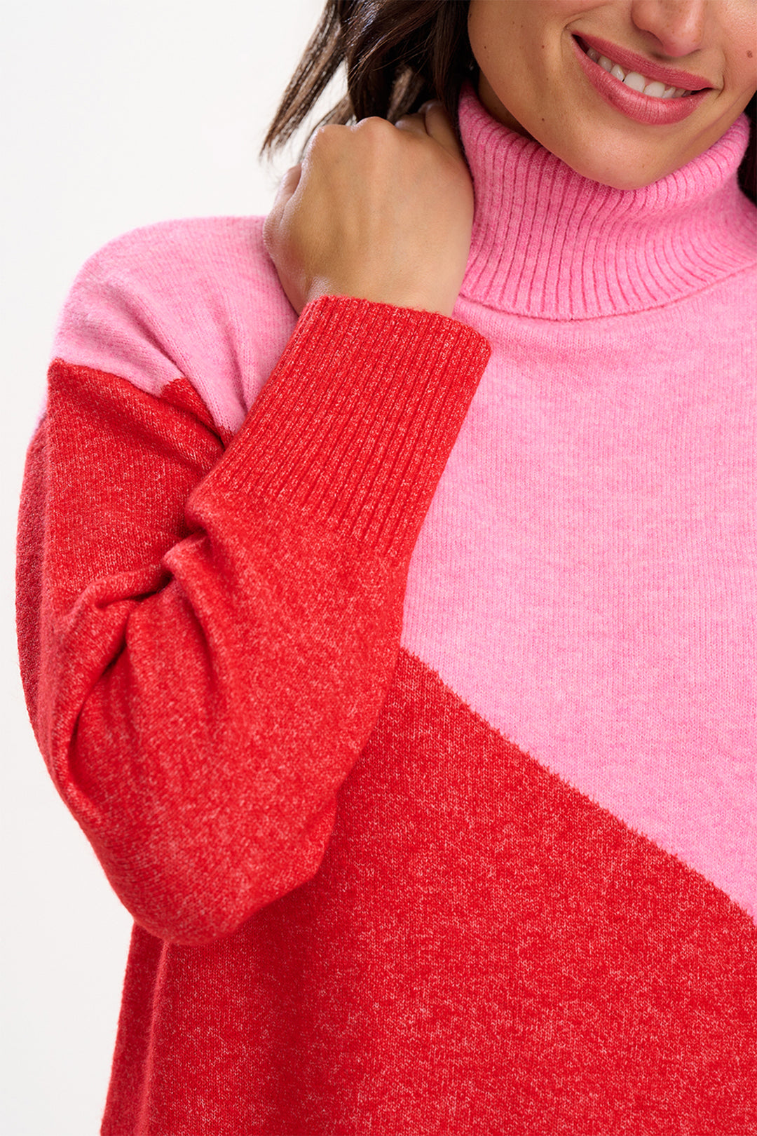 Close-up of a person wearing a pink and red sweater with a blurred background