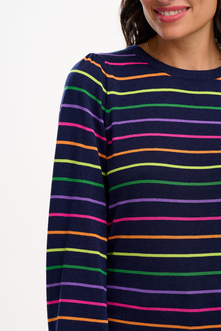 Navy sweater with multicolored stripes worn by a person on a white background