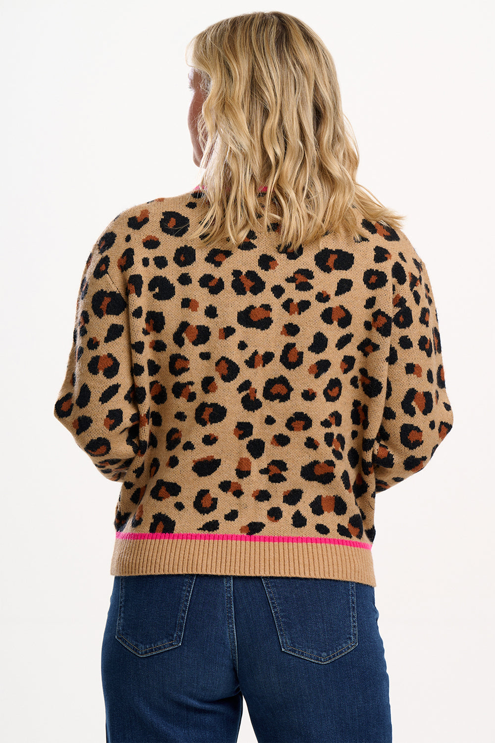 Person wearing a leopard print sweater with a pink trim on a white background