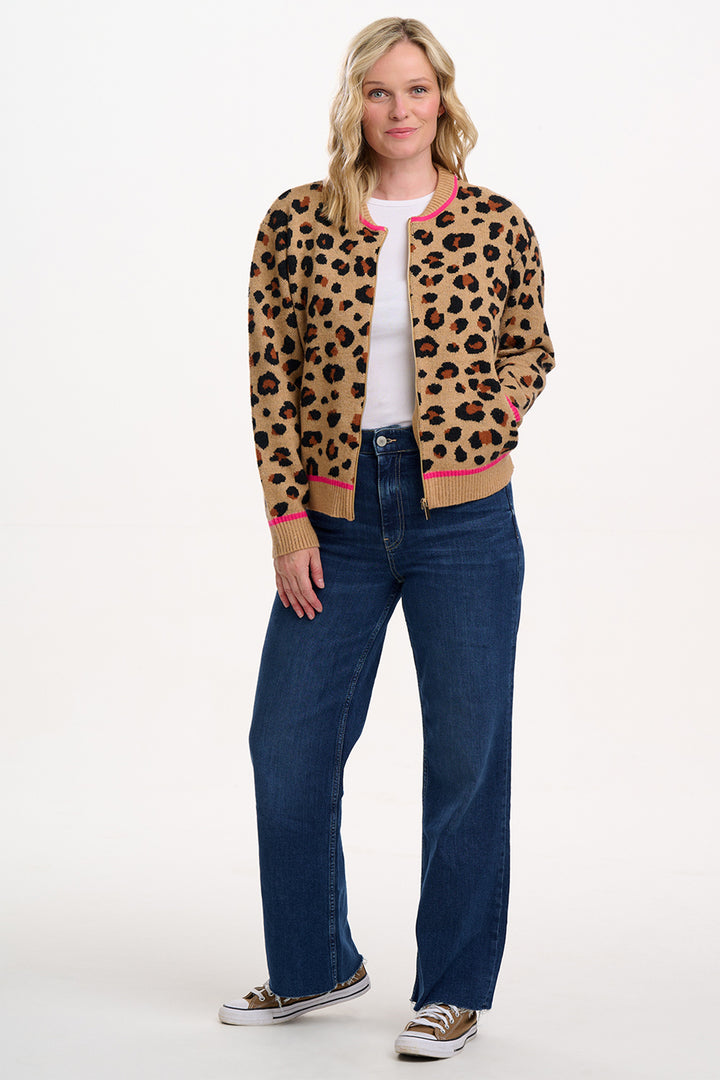 Woman wearing a leopard print jacket, white shirt, and blue jeans on a white background