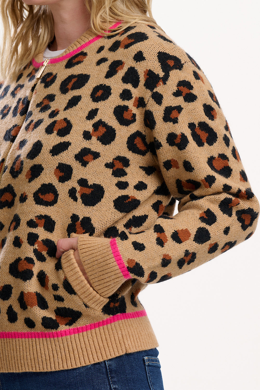 Leopard print sweater with pink accents worn by a person on a white background