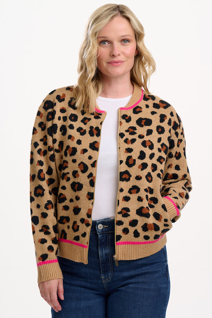 Woman wearing a leopard print cardigan with pink trim on a white background